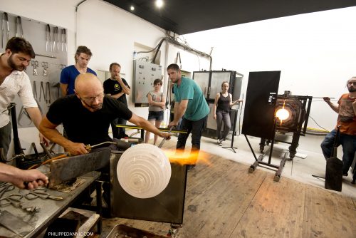 Group of students assisting glass maker in his glasswork ©Philippe Dannic